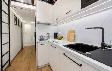 Biala kuchnia i antresola mikroapartament realizacja Komandor