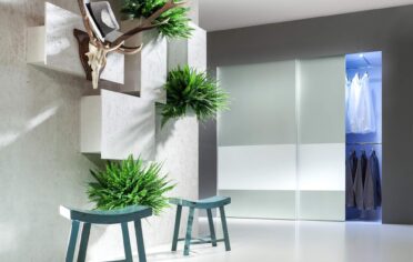 Minimalistyczny przedpokoj z dwudrzwiowa podswietlana szafa ze szklem