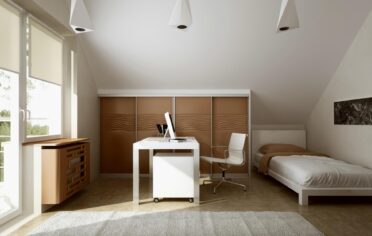 Mlodziezowy pokoj z niska szafa na skosie i lozkiem